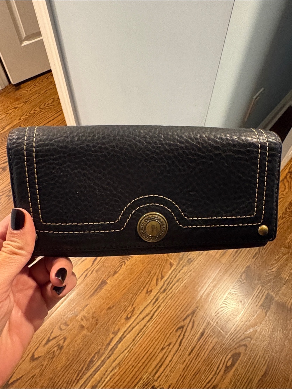 Coach Black Leather Wallet with Contrast Stitching and Coach Button closure.